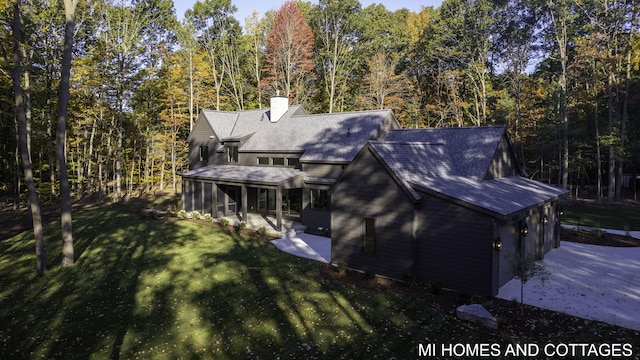 exterior space featuring a yard and a sunroom