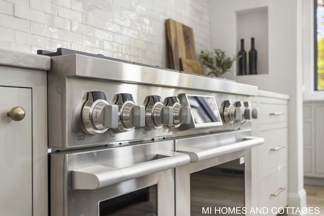 interior details with stainless steel range and decorative backsplash