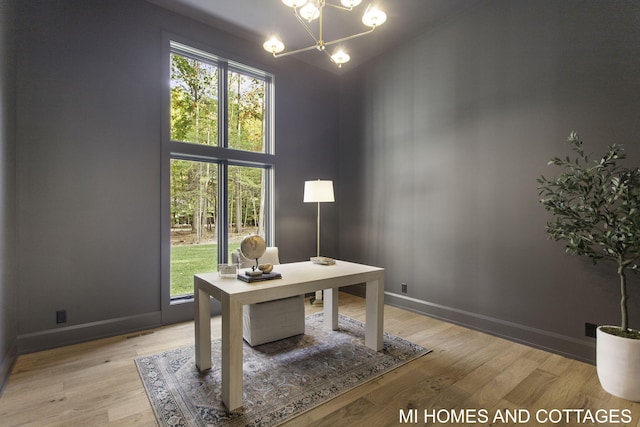 home office featuring a notable chandelier, a healthy amount of sunlight, and wood-type flooring