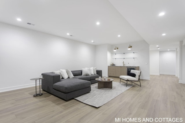 living room with light hardwood / wood-style floors and sink