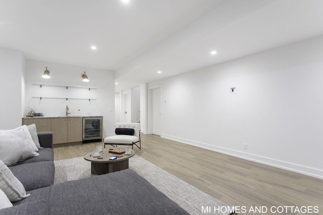 living room featuring indoor bar, light hardwood / wood-style floors, and beverage cooler