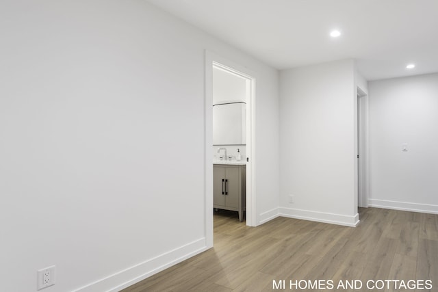 spare room with sink and light hardwood / wood-style flooring