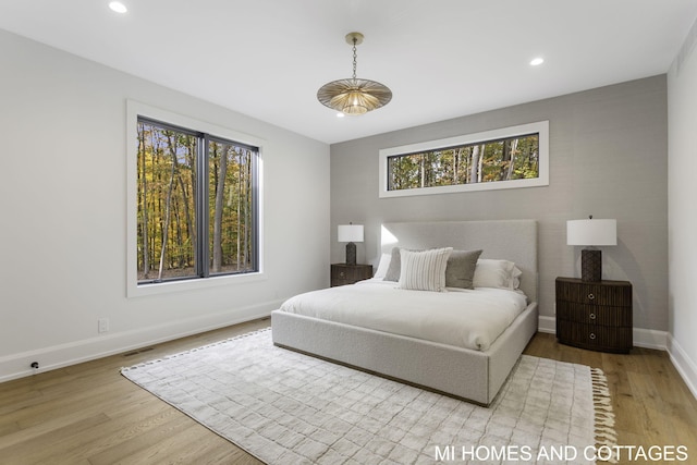 bedroom with light hardwood / wood-style floors and multiple windows