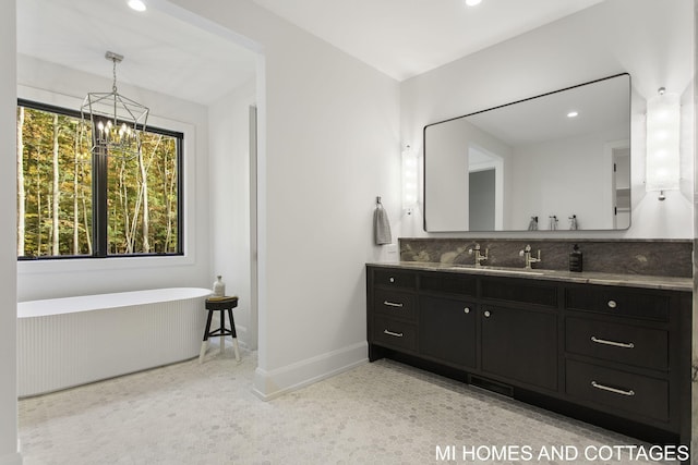 bathroom with vanity, a tub, and a notable chandelier