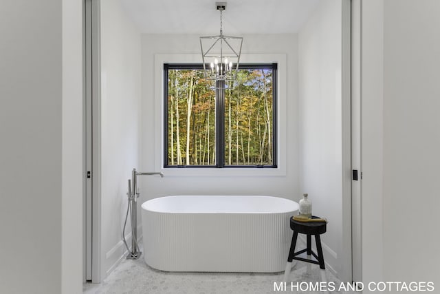 bathroom with a notable chandelier and a bath