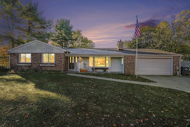 single story home featuring an attached garage, brick siding, driveway, a lawn, and a chimney