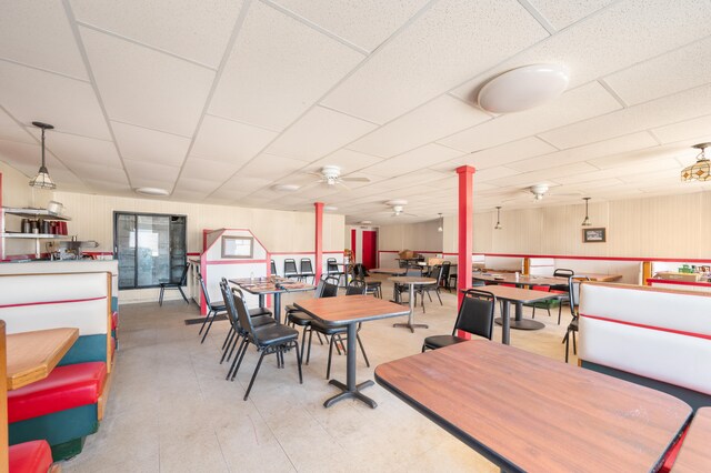 dining space featuring ceiling fan and a paneled ceiling