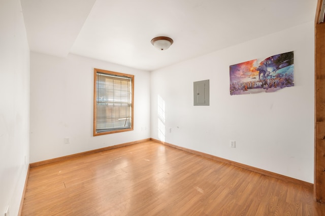 unfurnished room with electric panel and light wood-type flooring