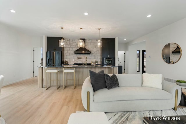 living room with sink and light hardwood / wood-style floors