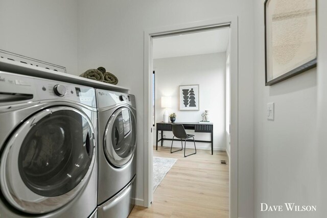 laundry room featuring washer and clothes dryer and light wood-type flooring