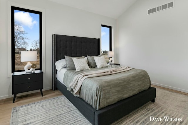 bedroom featuring hardwood / wood-style floors and lofted ceiling