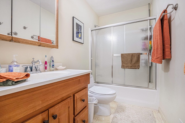 full bathroom featuring vanity, toilet, and shower / bath combination with glass door