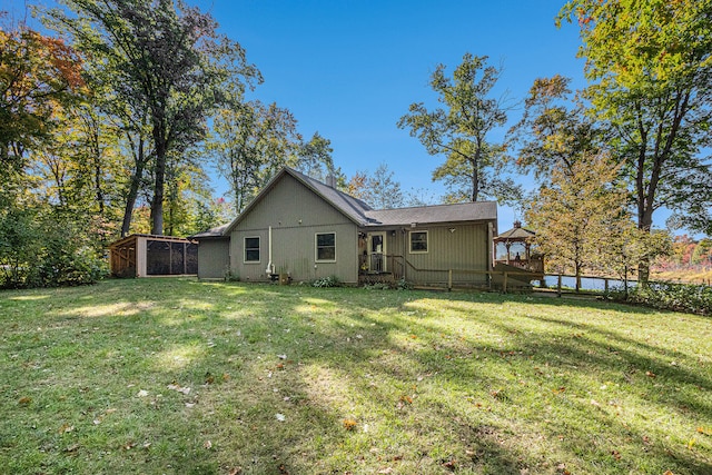 rear view of house with a yard and a sunroom