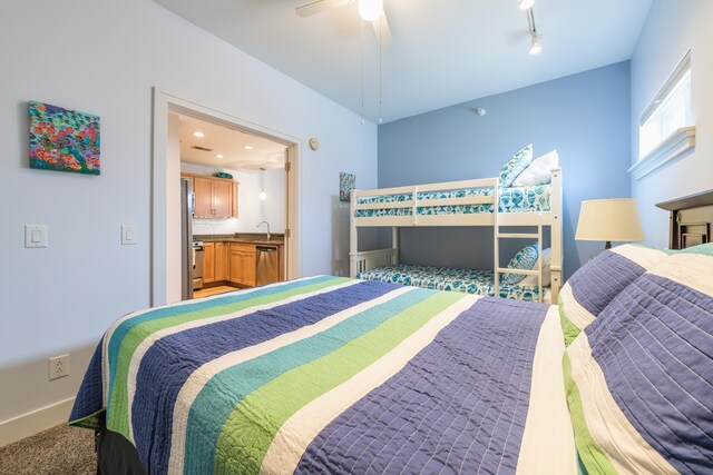 carpeted bedroom featuring ceiling fan and sink