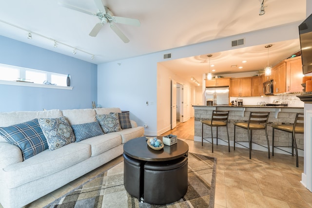 living room featuring rail lighting, ceiling fan, and light tile patterned floors