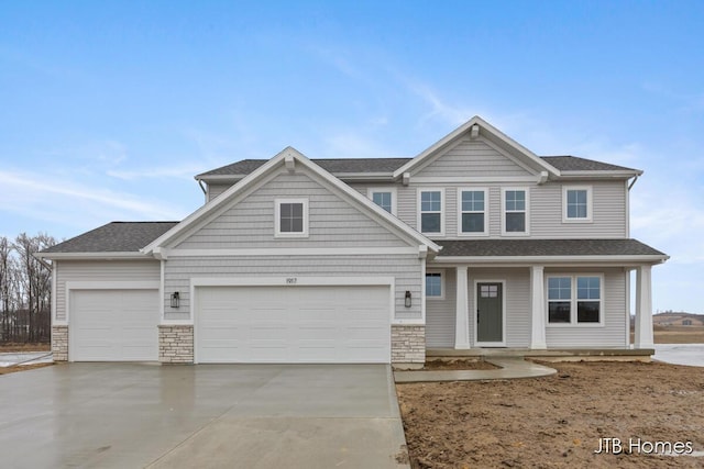 view of front of property featuring a garage, stone siding, and driveway