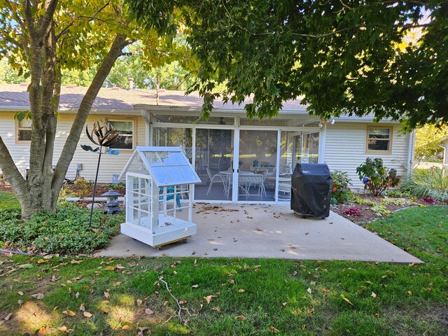 back of property with a sunroom and a patio area