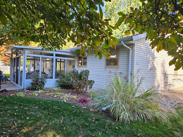 exterior space featuring a sunroom and a yard