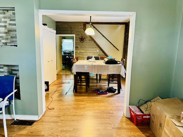 dining room with light hardwood / wood-style flooring and wood walls