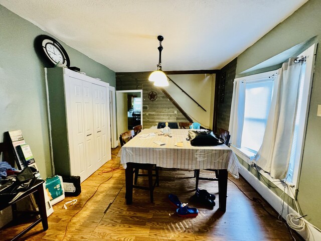 dining space with wood walls and hardwood / wood-style floors