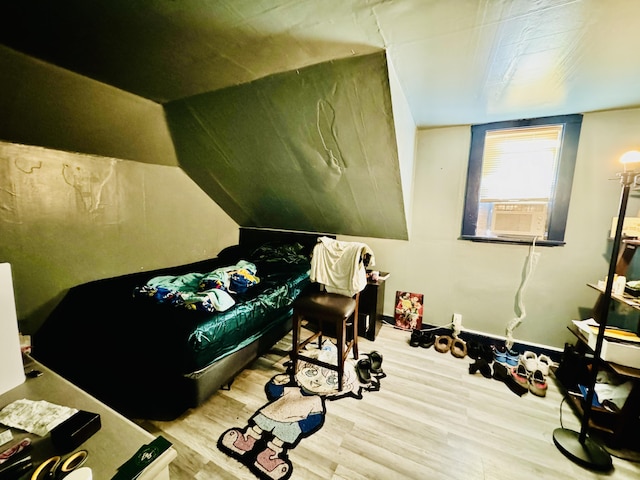 bedroom with cooling unit, wood-type flooring, and vaulted ceiling