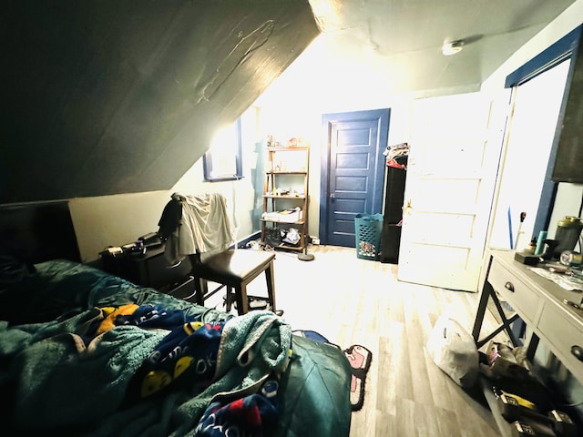 bedroom featuring light hardwood / wood-style flooring and lofted ceiling