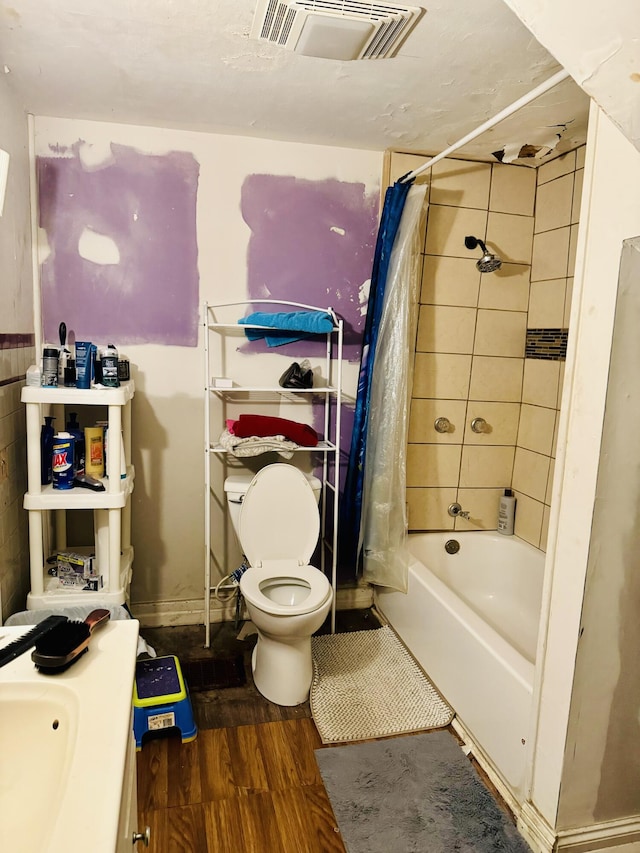 full bathroom with toilet, hardwood / wood-style floors, vanity, and shower / tub combo