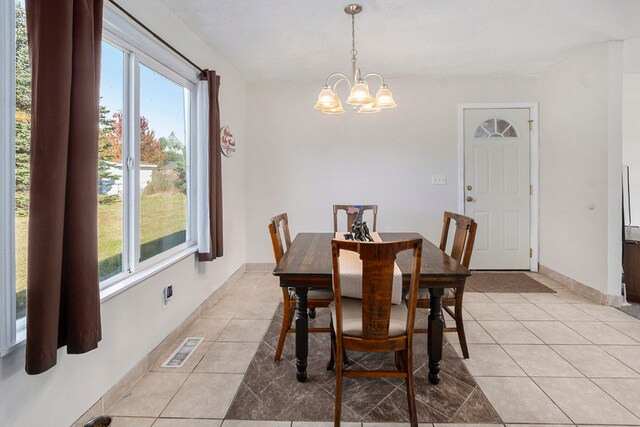 dining area featuring light tile patterned flooring and an inviting chandelier