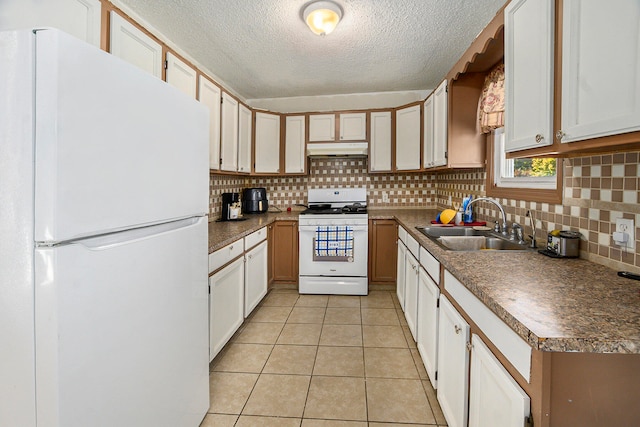 kitchen with sink, light tile patterned floors, white cabinets, white appliances, and tasteful backsplash