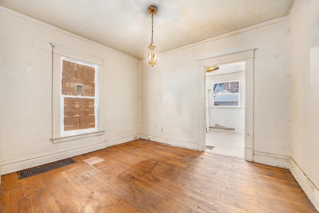 unfurnished room with wood-type flooring and ornamental molding