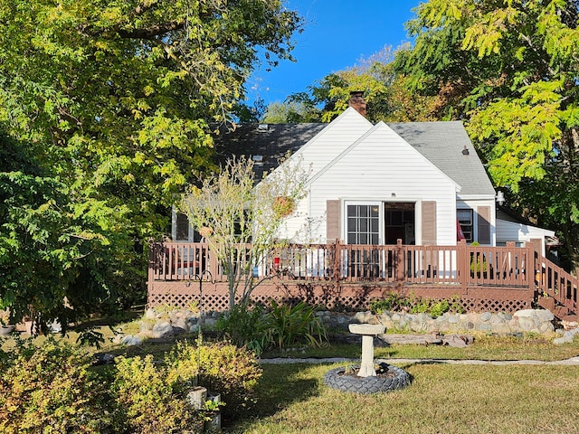 back of property featuring a deck and a lawn