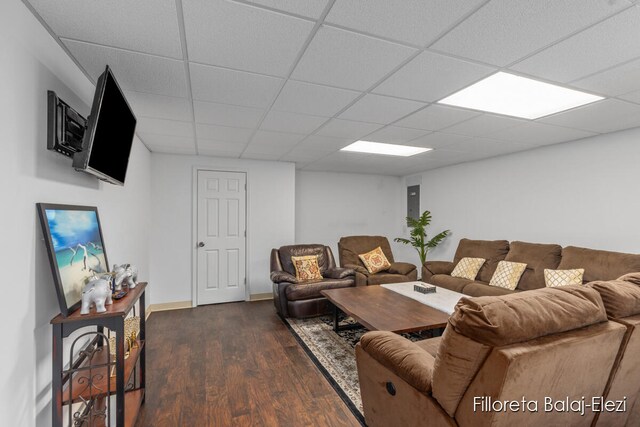 living room featuring dark wood-type flooring and a drop ceiling