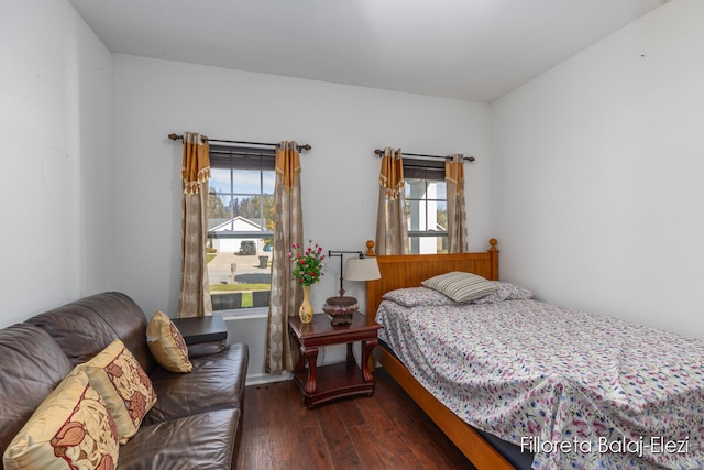 bedroom featuring multiple windows and dark hardwood / wood-style flooring