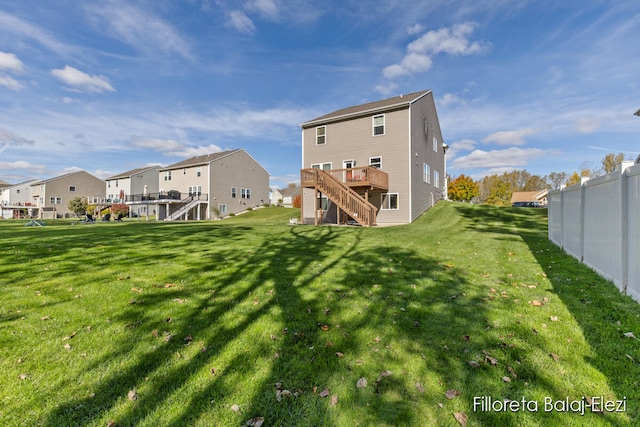 back of house featuring a deck and a lawn