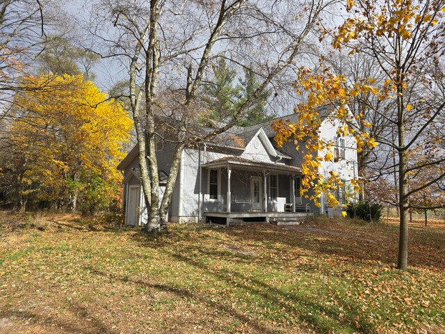 exterior space with covered porch and a front yard