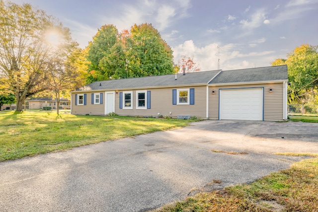 ranch-style home with a garage and a front lawn