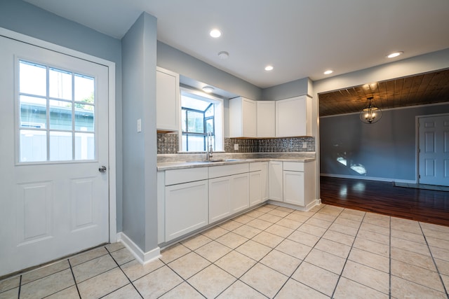 kitchen featuring white cabinets, light tile patterned flooring, and plenty of natural light