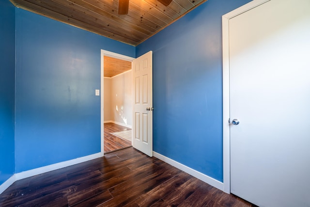 spare room featuring wood ceiling and dark hardwood / wood-style flooring