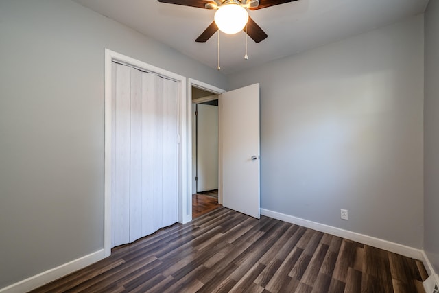 unfurnished bedroom featuring dark wood-type flooring, a closet, and ceiling fan