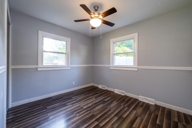 spare room with dark wood-type flooring, ceiling fan, and plenty of natural light