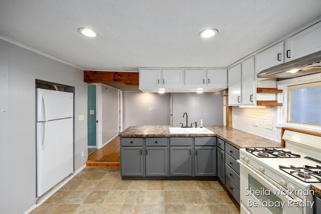 kitchen with white appliances, sink, kitchen peninsula, and gray cabinetry