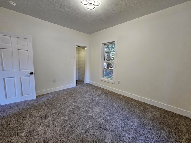 unfurnished room featuring a textured ceiling and carpet flooring