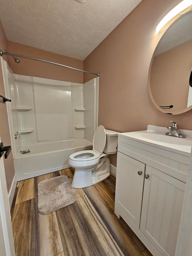 full bathroom with hardwood / wood-style flooring, toilet, bathtub / shower combination, vanity, and a textured ceiling