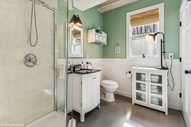 bathroom featuring toilet, walk in shower, a healthy amount of sunlight, and vanity