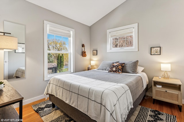 bedroom with lofted ceiling and hardwood / wood-style floors