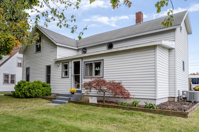 back of house featuring a lawn and cooling unit