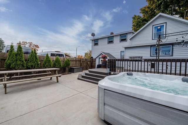 view of patio featuring a hot tub and a deck