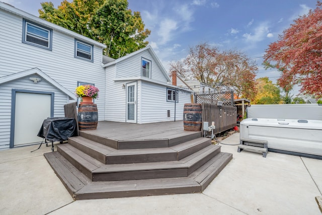 wooden terrace featuring area for grilling, a patio area, and a hot tub