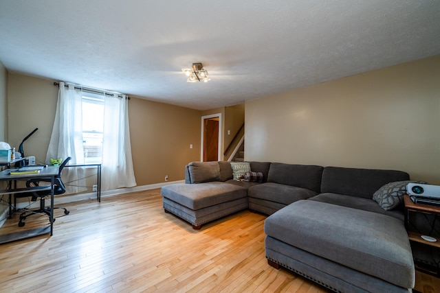 living room with a textured ceiling and light wood-type flooring