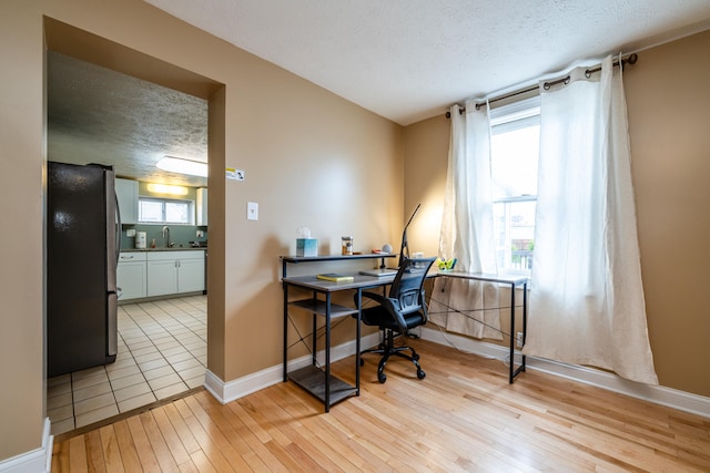 office with a textured ceiling and light hardwood / wood-style flooring